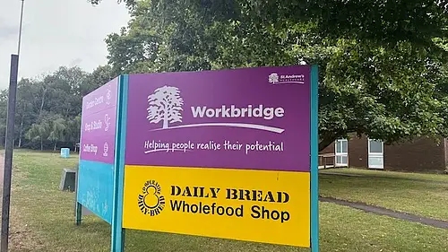 Photo of a purple sign with the text Workbridge on a purple background